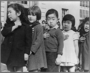 Japanese children with their hands covering their hearts
