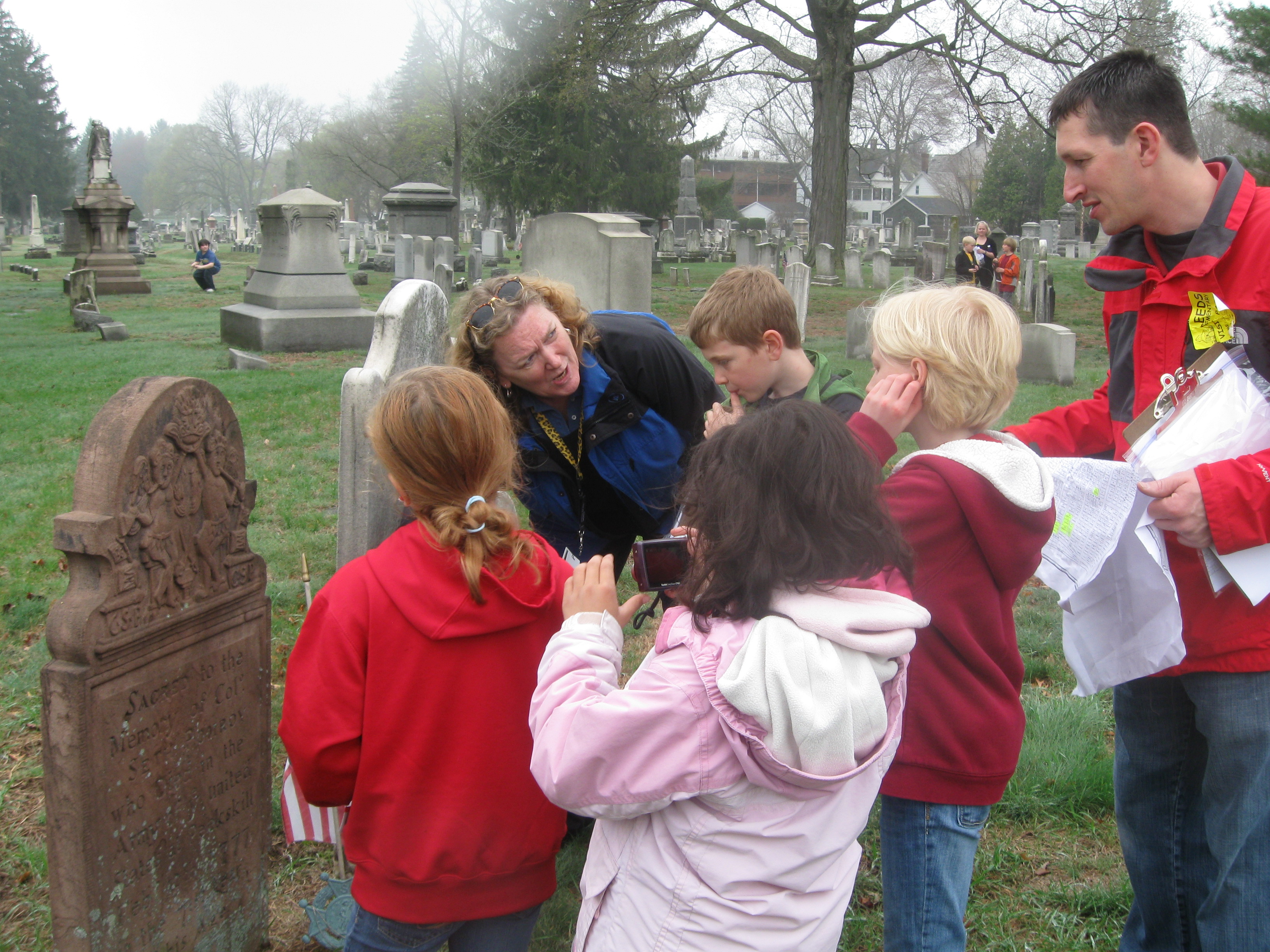 Header Photo - Denise Wood, Leeds Elementary School, Northampton, leads students in a study trip to the Bridge Street Cemetery in search of stories of Revolutionary War soldiers.