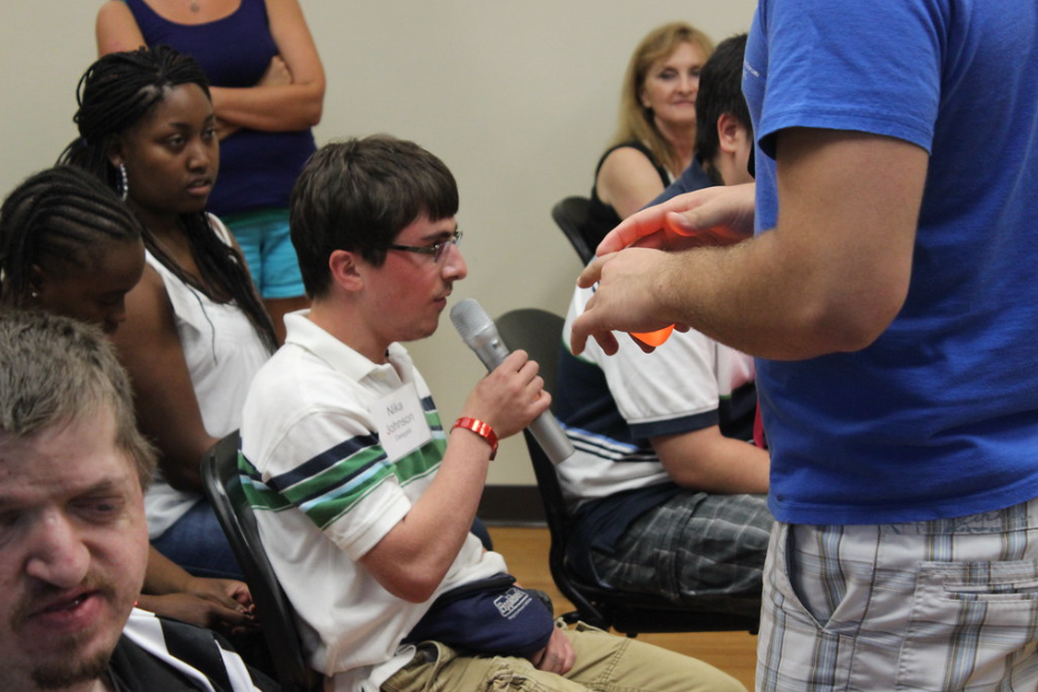 Teen with microphone speaks at a community meeting.