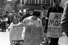 Protesters, black and white, walking and in wheelchairs, carry signs demanding "Access to Work" and "Sign 504"