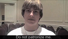 A young man with short blond hair looks at the camera - a caption reads "Do Not Patronize Me".